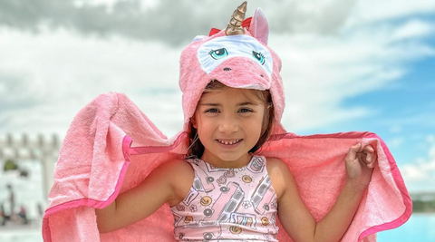 a girl child flaunting her kloud bambu pink unicorn bamboo hooded bath towel