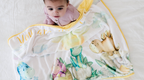 a baby with his kloud bambu dinosaur minky blanket