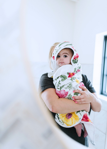 a baby wrapped in kloud bambu floral hooded towel