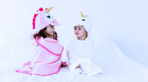 two girl children wrapped in kloud bambu unicorn hooded bath towels