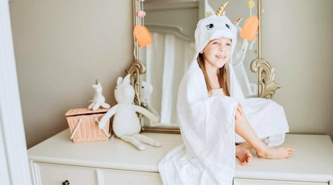 a girl child sitting at the table after taking a bath