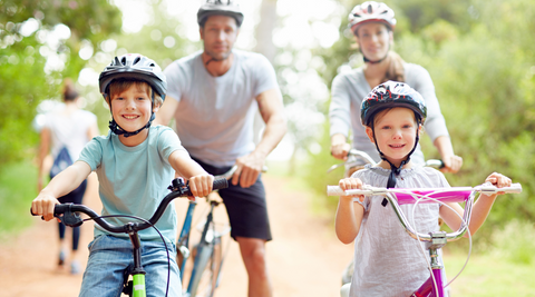 a family of four enjoying biking during summertime