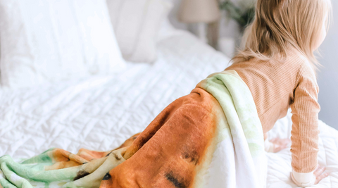 baby girl crawling on bed with her kloud bambu minky blanket