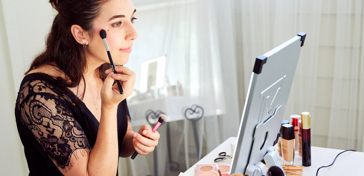 Woman applies makeup using TML Meira lighted mirror makeup vanity