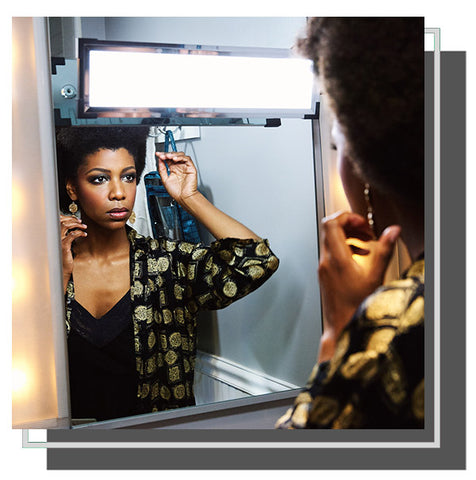 Woman checking her reflection in mirror with Eyelight