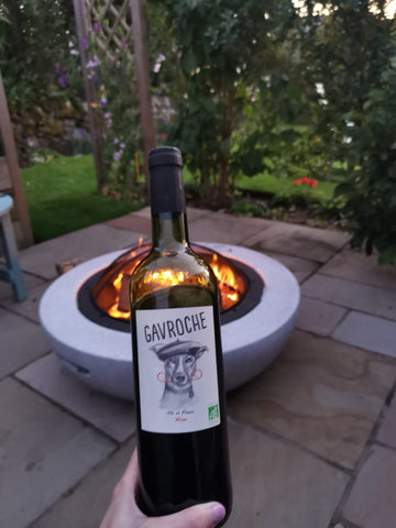 Photo shows the wine in front of a firepit in a pleasant alfresco scene