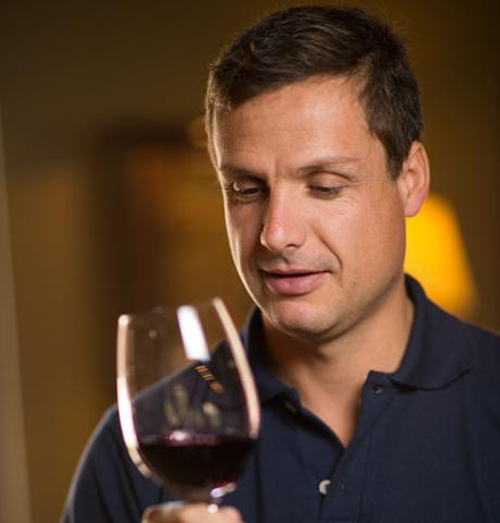 A man holding a glass of Kaiken Malbec Clasico