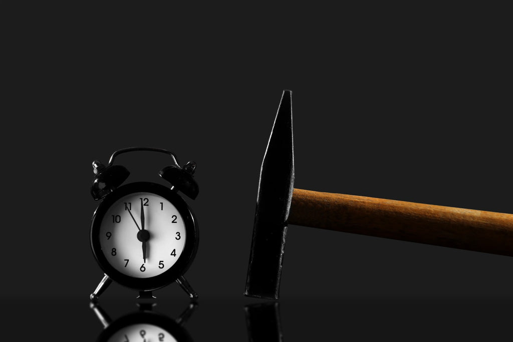 Black Alarm Clock Awakening User At 6am With Hammer Beside It