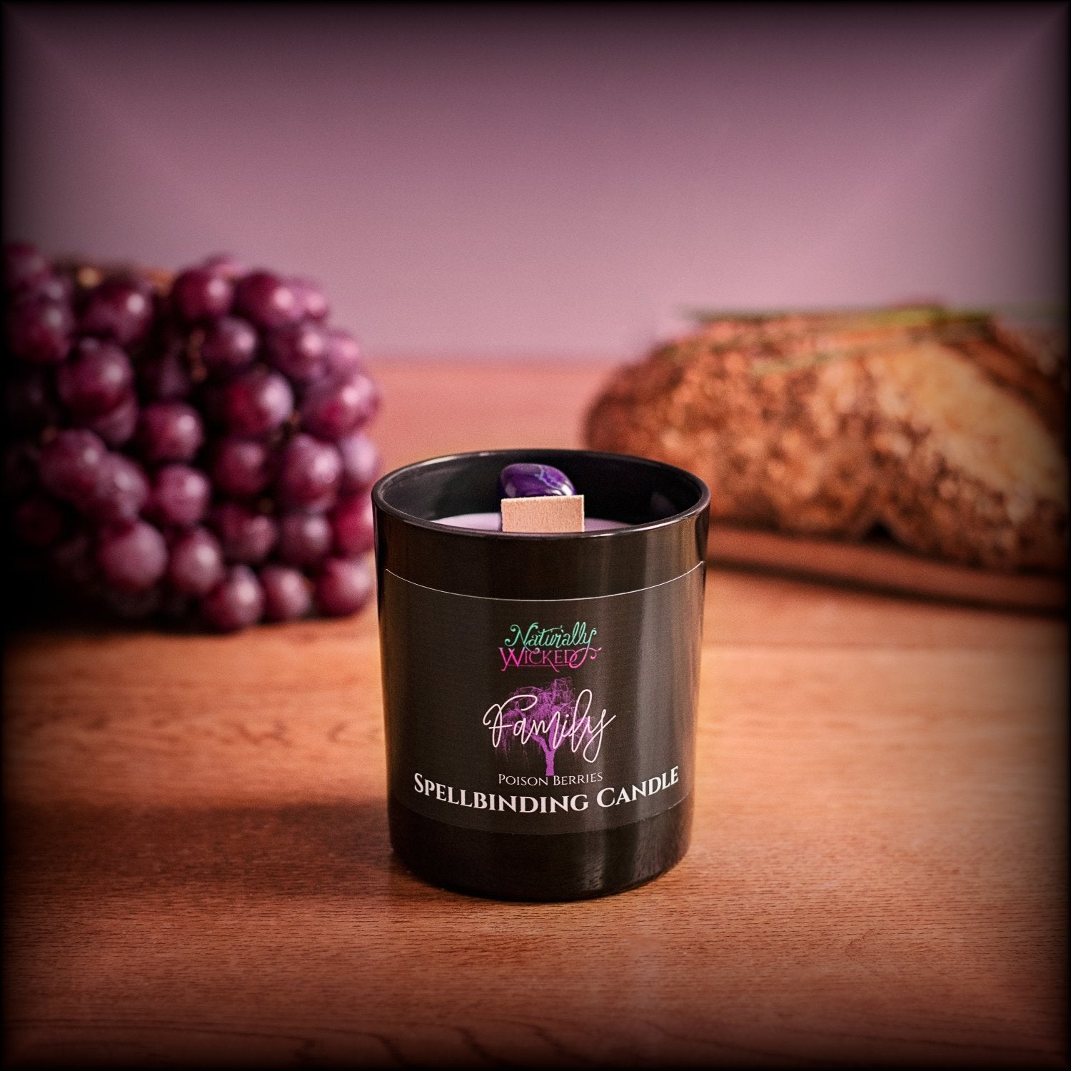 Naturally Wicked Spellbinding Family Candle With Bright Purple Family Crystal Sits In Front Of Purple Grapes & Home Cooked Bread