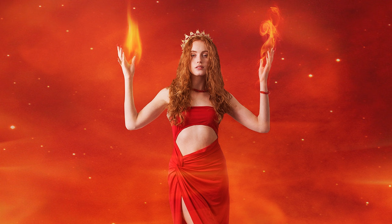 Naturally Wicked Fire Queen Dressed In Bright Redd Dress With Orange Flames Rising From Hands