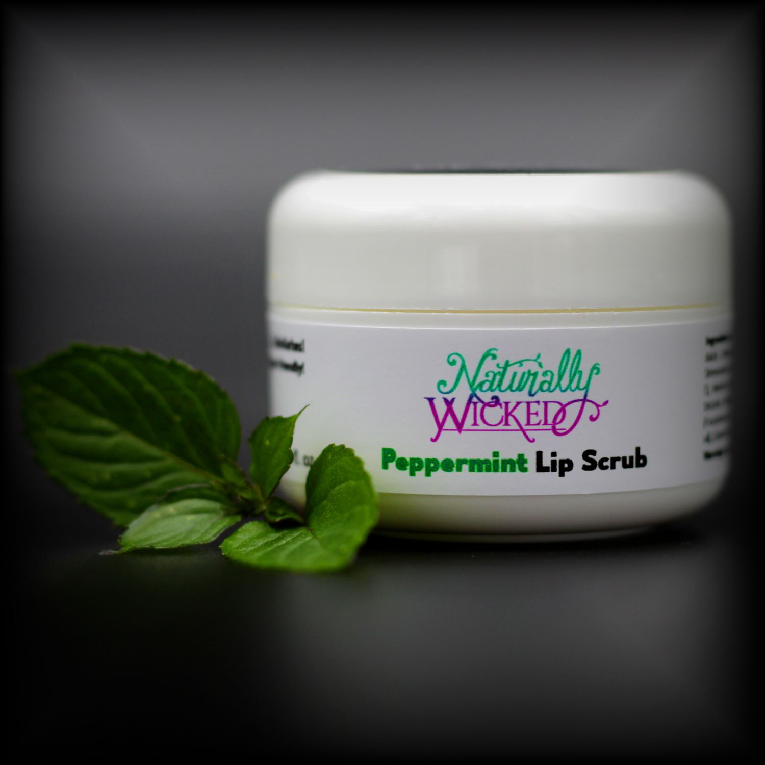 Naturally Wicked Peppermint Sugar Lip Scrub Surrounded By Refreshing Green Peppermint Leaves