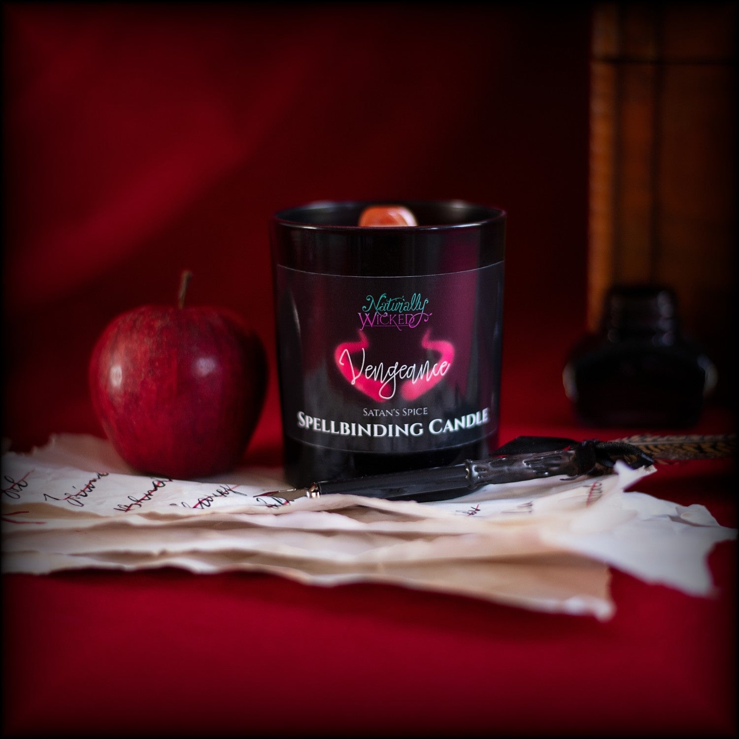 Naturally Wicked Spellbinding Vengeance Spell Candle Entombed With Carnelian Crystal Sits Amongst Revenge List & Red Apple