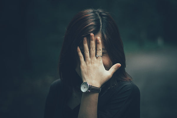 Girl hiding behind her hand