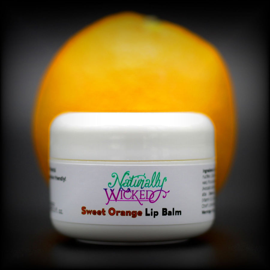 Naturally Wicked Sweet Orange Lip Balm Beside Bright, Juicy Orange Fruit