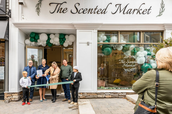 Kristy Miller cuts the ribbon at the Grand Opening of the new Scented Market store in the Blue Mountain Village. She is standing in front of the store surrounding by her family, the Deputy Mayor and the Mayor of The Town of the Blue Mountains.