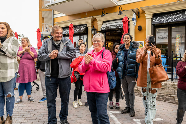 Friends, family, and shoppers clap at the Grand Opening ceremony of the new Scented Market store in the Blue Mountain Village.