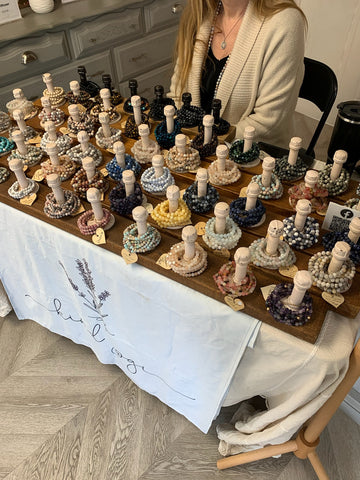 Gemstone bracelets are displayed on a table during a Maker Spotlight Saturday event.