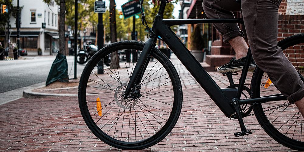 vélo électrique noir ville pavés rouges