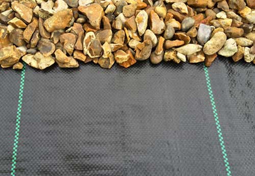 Woven geotextile fabric installed below gravel