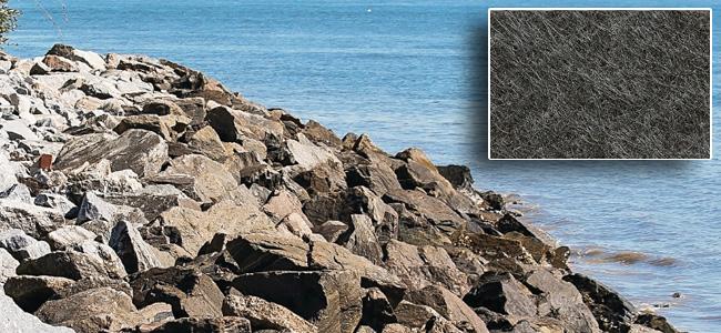 Erosion control fabric on shorline with large breakwater rocks on top