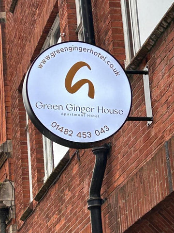 sign attached to brick wall, details the name of the hotel 'Green Ginger House'