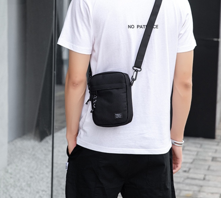 sacoche bandoulière portée de dos par un homme avec un tee-shirt blanc