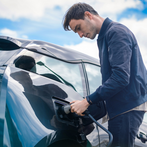 homme qui charge sa voiture électrique