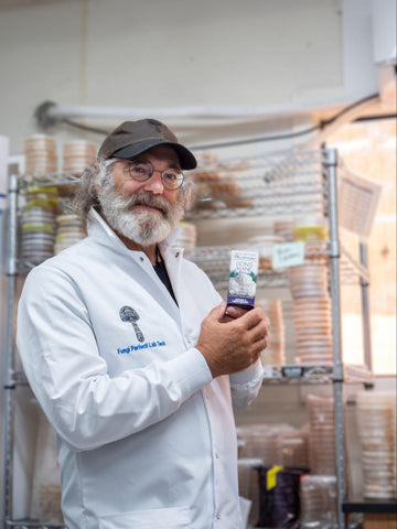 Paul Stamets holding Lion's Mane mushroom mycelium capsules.