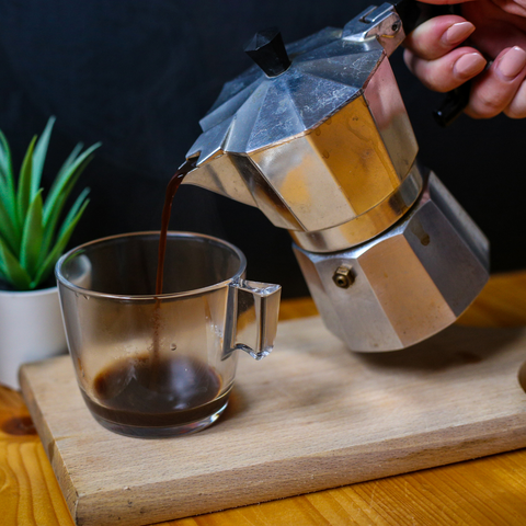 moka pot pouring coffee into mug