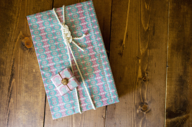  Nautical inspired gift wrapping featuring a half-hitch knot and cotton rope for beach-y, coastal look.  "Beach House" w rapping paper designed by Shay Spaniola for Bunglo.   