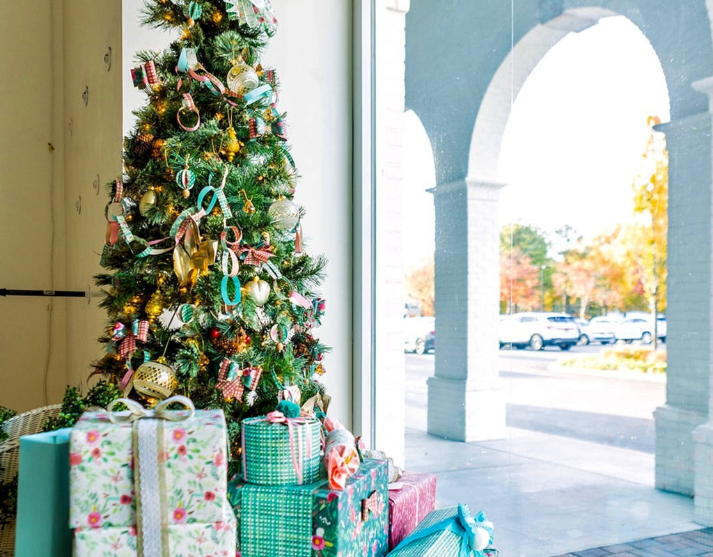 Decorated Christmas Tree with Stacks of Wrapped Gifts in a Store Window