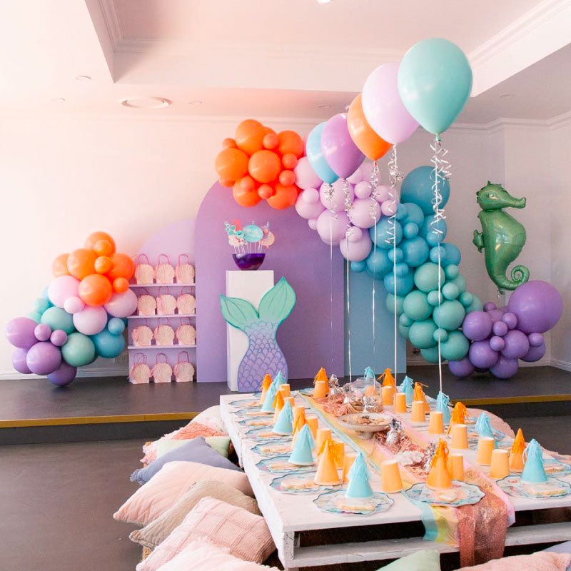 Mermaid party with balloon garlands displayed on wooden arch
