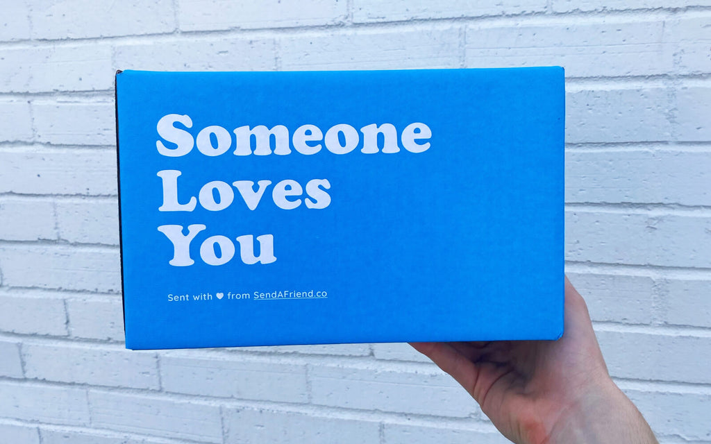person holding blue "someone loves you" box
