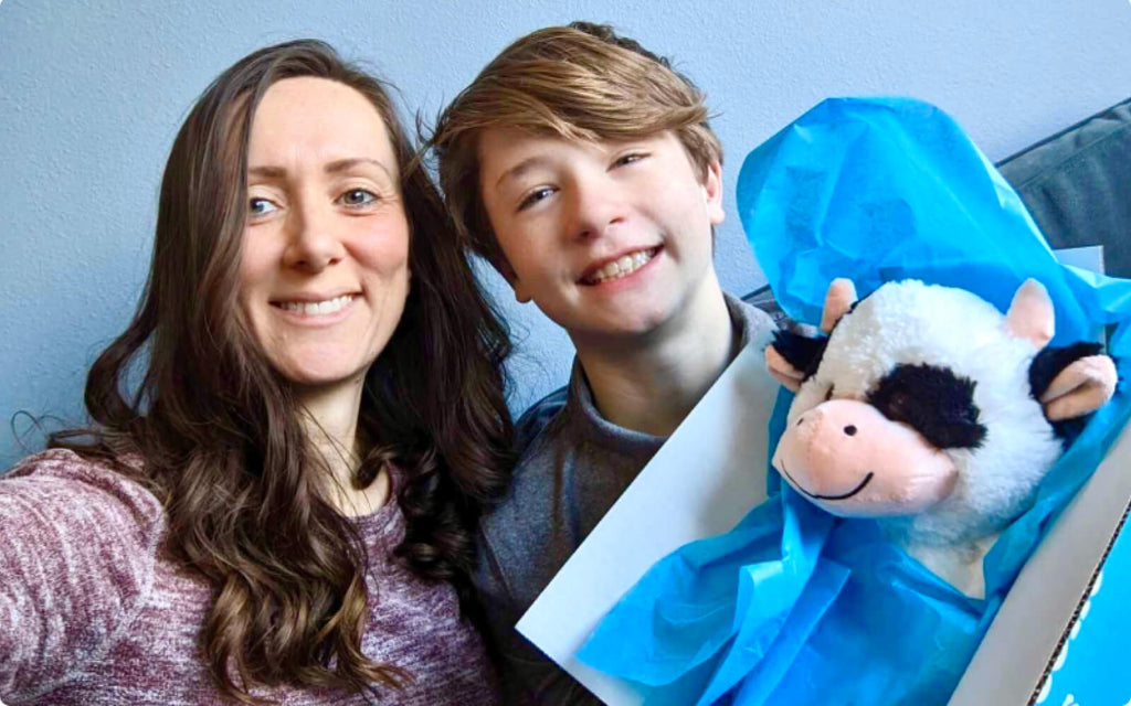 mother and son receiving stuffed cow care package