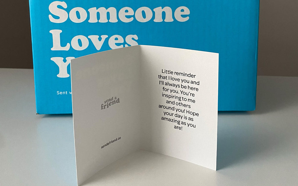 An image of the Someone Loves You note card in front of the Someone Loves You box. The note card reads: Little reminder that I love you and I'll always be here for you. You're inspiring to me and others around you! Hope your day is as amazing as you are!