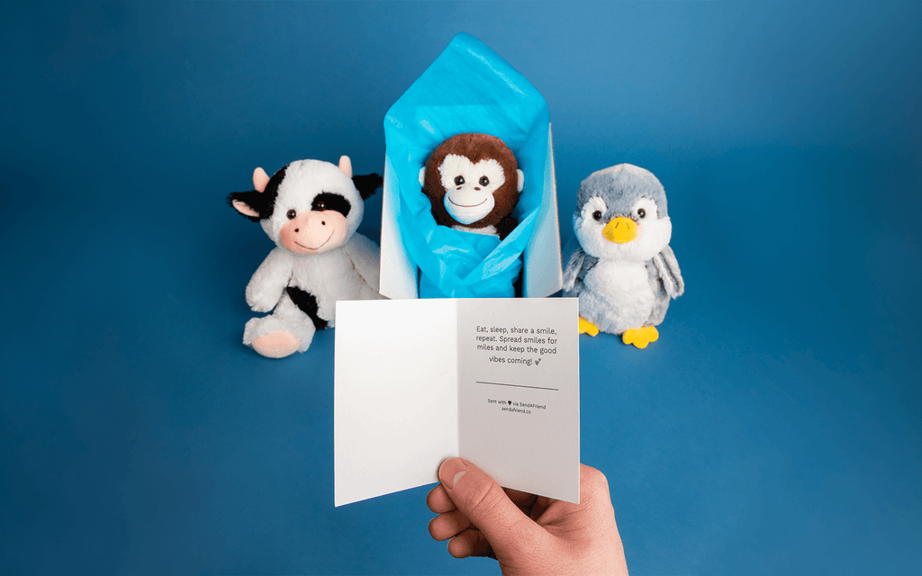 A note card that reads: "Eat, sleep, share a smile, repeat. Spread smiles for miles and keep the good vibes coming". Cooper the Cow, Maria the Monkey, and Pepper the Penguin in the background.