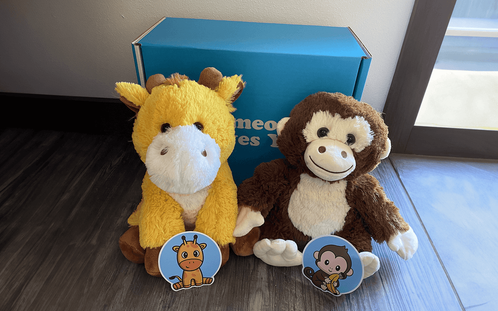 Image of George the Giraffe and Maria the Monkey with their matching stickers, Someone Loves You box in the background