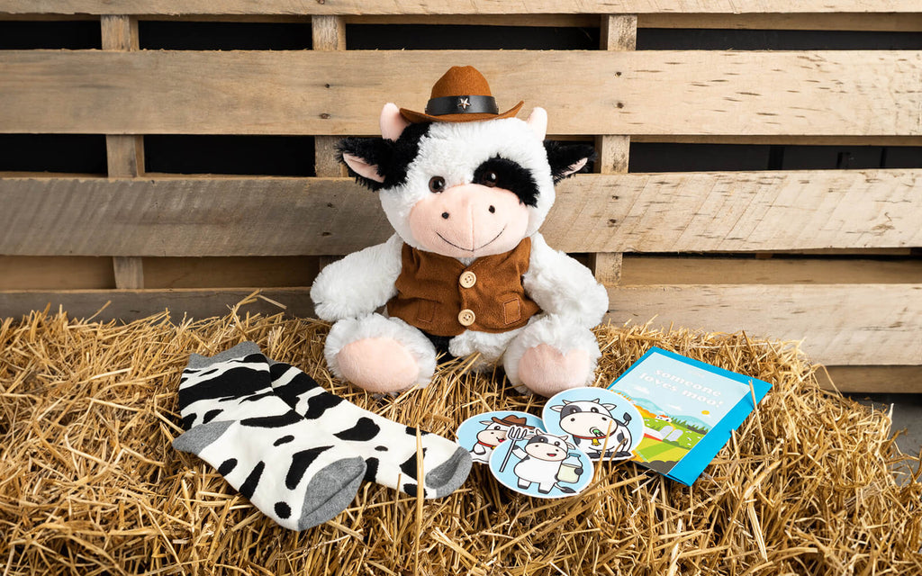 Image of Cowboy Cooper Bundle featuring Cooper the Cow sitting on a bale of straw in a barn like setting