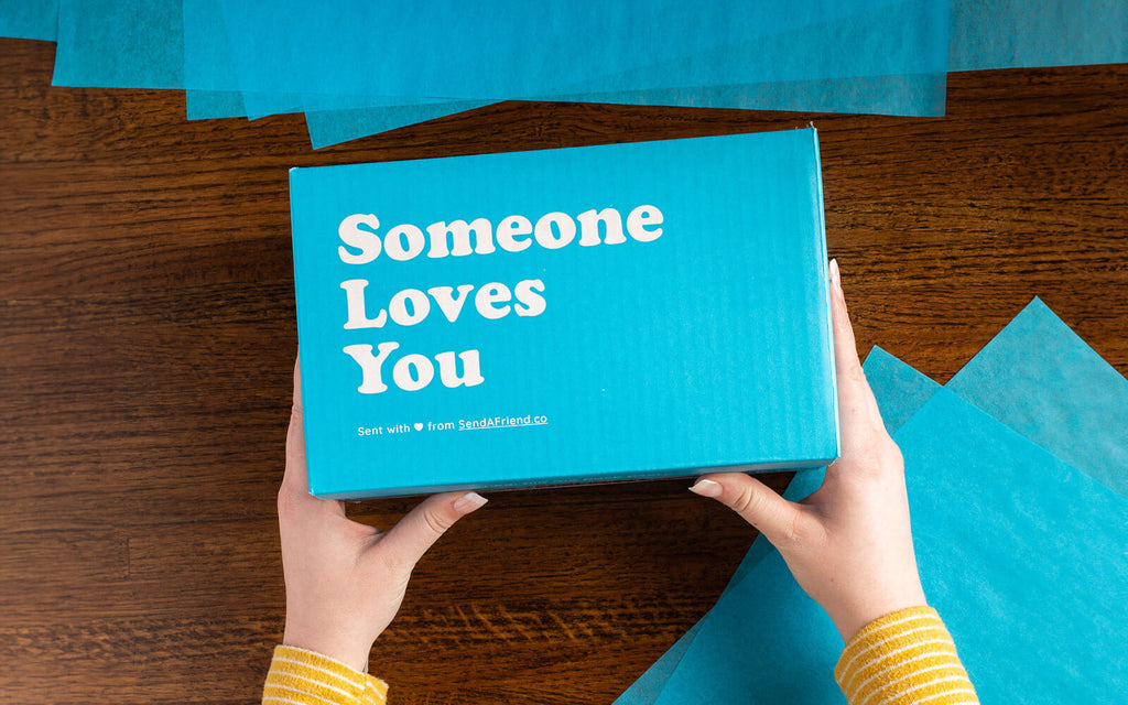 An image of hands on the the Someone Loves You box