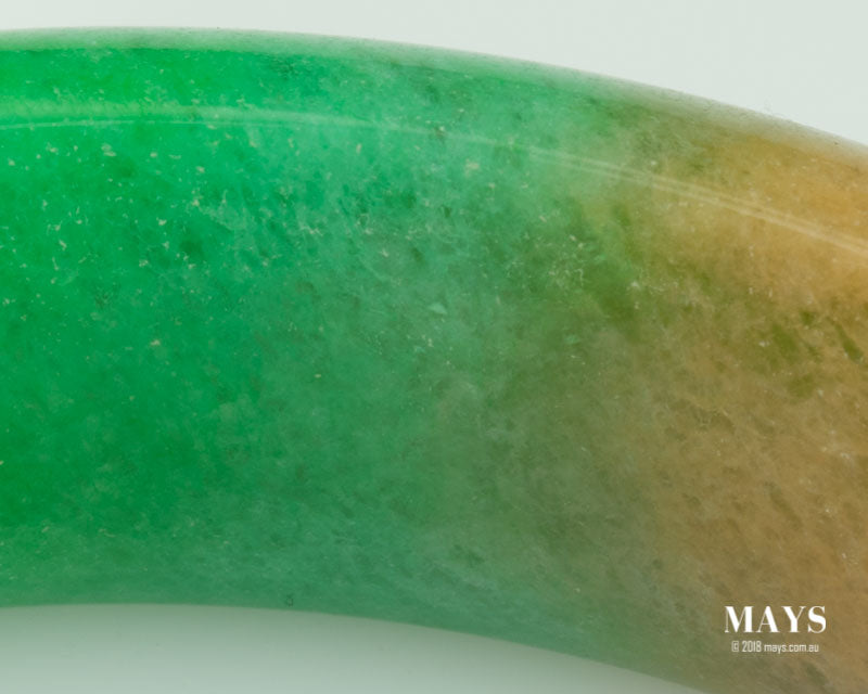 Discolured Treated Jade Bangle Internal degradation of polymer showing discolouration and coarse texture.