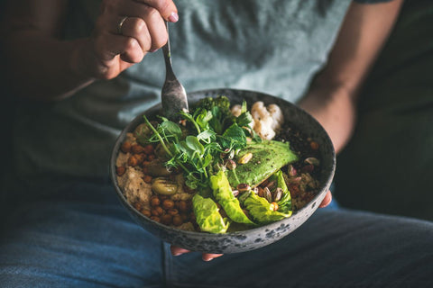 Woman eating healthy vegan food from bowl