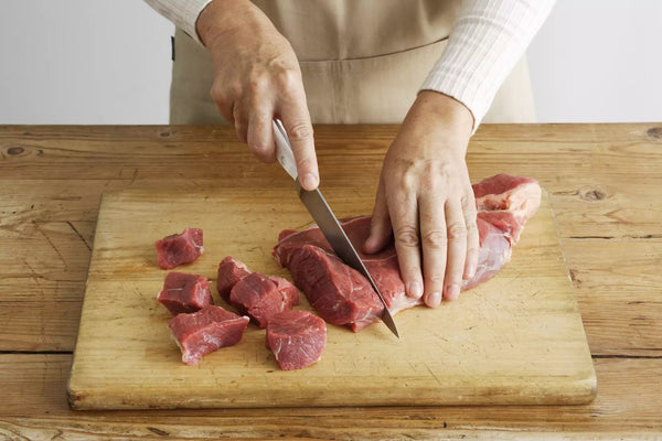 picando carne en tabla de cortar