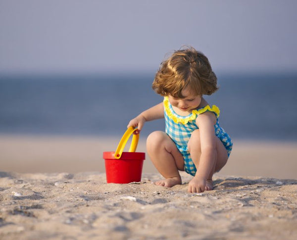 niña recogiendo conchas marinas en la playa