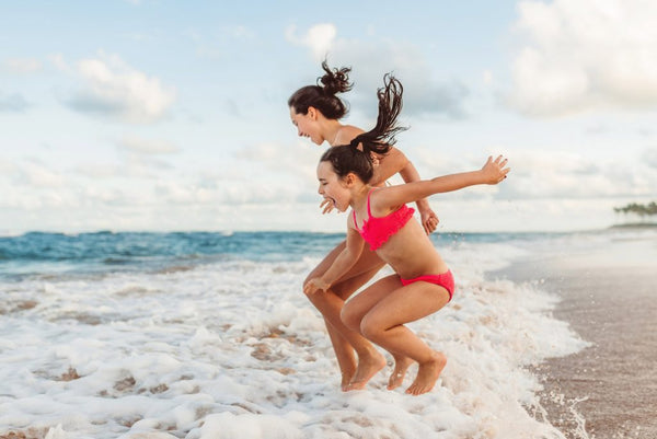 niñas saltando en la orilla de la playa