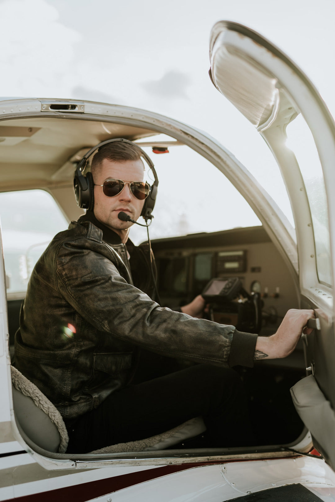 man getting into airplane with modern bomber jacket