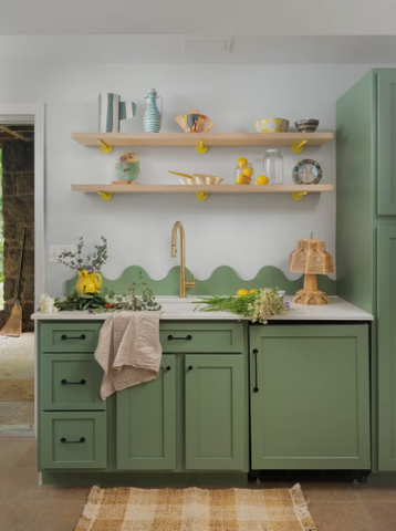 A green painted kitchen with open shelving