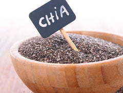 wooden bowl full of black chia seeds with chalkboard sign labeled chia