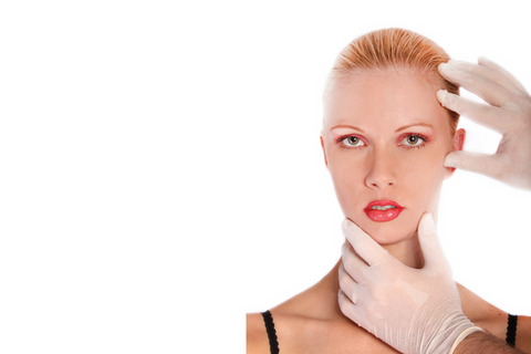 woman with hair pulled back with white gloved hands touching her face