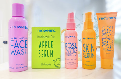 five of Frownies skincare products lined up on a bathroom countertop