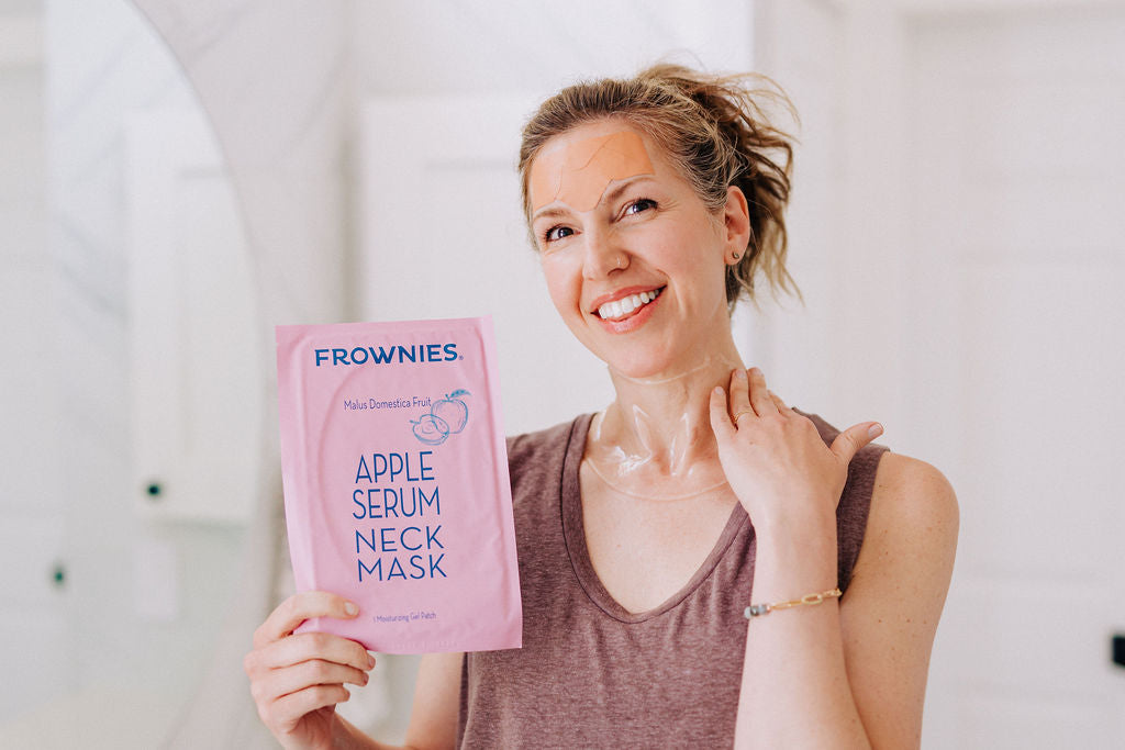 woman wearing wrinkle patches on her forehead and a hydrating neck mask